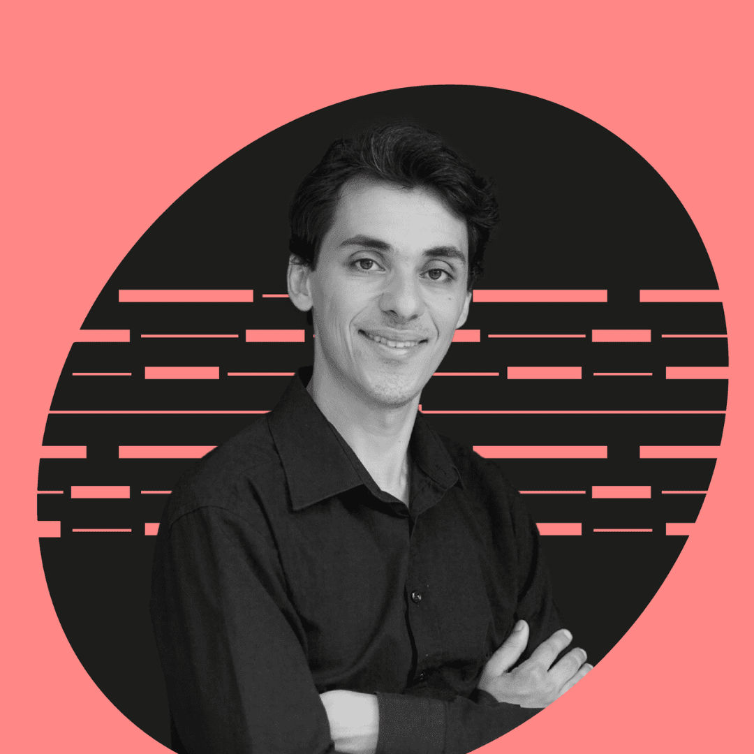A person with dark hair, wearing a black shirt, smiles confidently with arms crossed. The background features a black oval with pink lines on a solid pink backdrop.